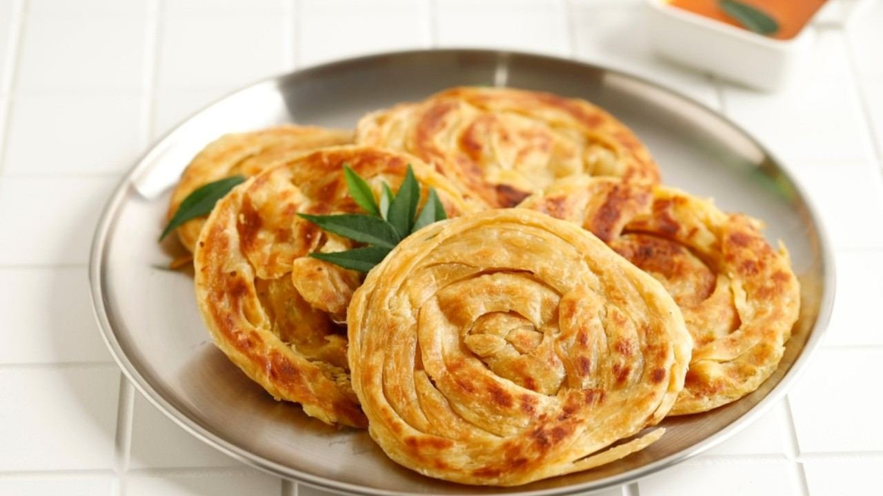 Roti canai hangat dengan tekstur berlapis dan kuah kari