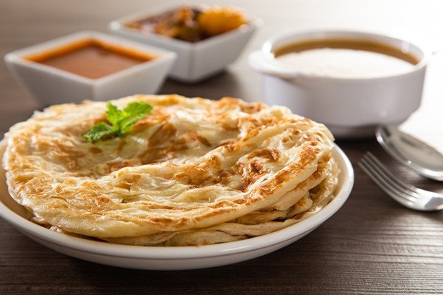 Roti canai disajikan bersama kuah kari dan sambal